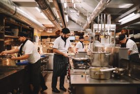 Restaurant kitchen crew preparing food.